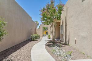 a walkway between two buildings with trees on either side at Las Cruces Vacation Rental Near Trails and Golf! in Las Cruces