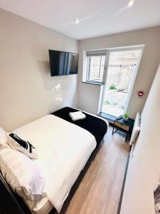 ein Schlafzimmer mit einem großen Bett und einem TV in der Unterkunft Central Studio Like a Hotel Room in London