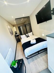 a bedroom with a bed and a flat screen tv at Central Studio Like a Hotel Room in London