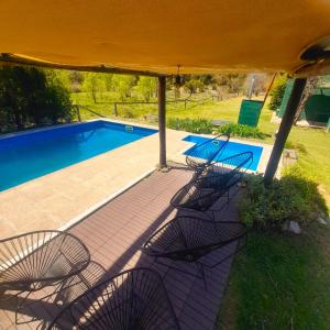 un grupo de sillas sentadas junto a una piscina en Los Bambues Cabañas en El Volcán