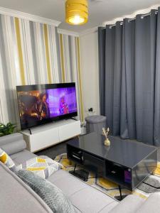 a living room with a tv and a table at Home in Medway in Gillingham