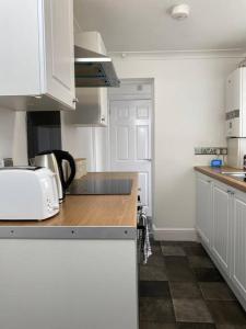 a kitchen with white cabinets and a counter top at Home in Medway in Gillingham