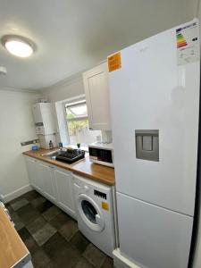 a kitchen with a white refrigerator and a washing machine at Home in Medway in Gillingham