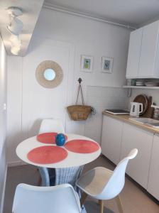 a kitchen with a table and chairs in a room at APARTAMENT NIEBO in Kołobrzeg