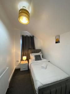 a small bedroom with a bed and a lamp at Home in Medway in Gillingham