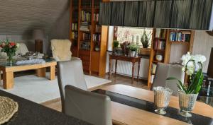 uma sala de estar com mesa, cadeiras e estantes em Ferienwohnung Katinka Wiese em Burg