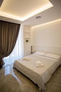 a bedroom with a bed with two towels on it at Forever Luxury Rooms in Castellammare di Stabia