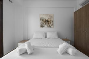 ein Schlafzimmer mit einem weißen Bett und Handtüchern darauf in der Unterkunft #Luxlikehome Seashell Villa in Posidi