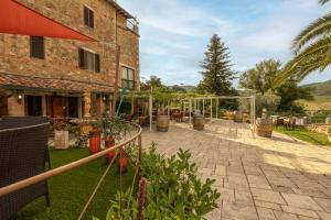 un cortile con una serra e un edificio di B&B Locanda Sant'Antimo a Montalcino