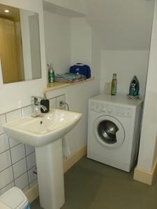 a bathroom with a sink and a washing machine at The Old Map Shop in Wigton