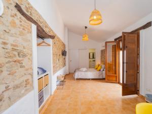 Cubo's La Casa del Arco Room Pajaro في كارتاما: غرفة نوم بسرير وجدار حجري