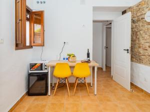 Cubo's La Casa del Arco Room Pajaro في كارتاما: مطبخ بطاوله وكرسيين اصفر