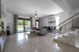 ein Wohnzimmer mit einem Sofa und einem Tisch in der Unterkunft #Luxlikehome Seashell Villa in Posidi