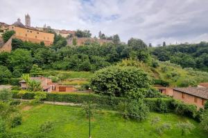 a view of a village with a green yard at Casa Duccio alle Mura della Città in Siena