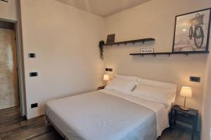 a bedroom with a white bed and two lamps at Casa Duccio alle Mura della Città in Siena
