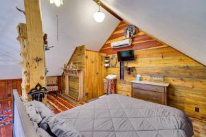 - une chambre avec un lit dans une pièce dotée de murs en bois dans l'établissement Pet-Friendly Eureka Springs Rental with Private Deck, à Eureka Springs