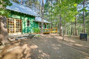 uma casa verde no meio de uma floresta em Pet-Friendly Eureka Springs Rental with Private Deck em Eureka Springs