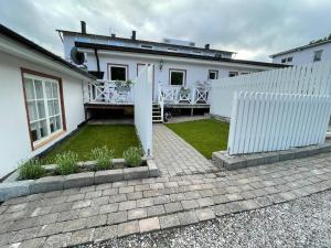 a white house with a fence and a yard at Enkelheten i Kivik in Kivik