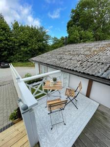 a patio with a table and chairs on a deck at Enkelheten i Kivik in Kivik +7 photos