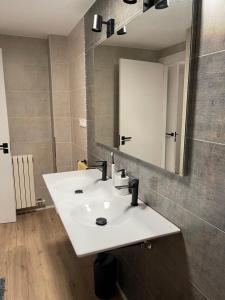 ein Badezimmer mit einem weißen Waschbecken und einem Spiegel in der Unterkunft Villa Elena Can Quintana in Pineda de Mar