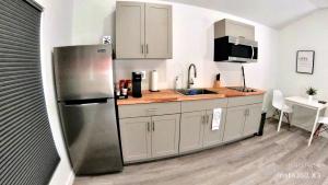 cocina con nevera de acero inoxidable y fregadero en All modern Studio with private entry & parking., en Brandon