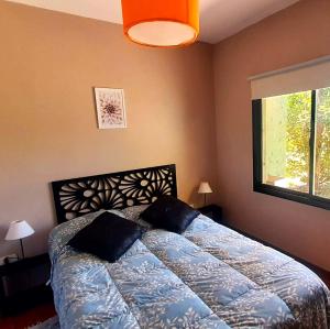 a bedroom with a bed and a window at Los Bambues Cabañas in El Volcán +27 photos