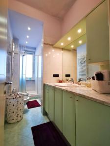 ein Badezimmer mit einem Waschbecken und einem großen Spiegel in der Unterkunft Ana's Place Torino 3 in Turin