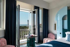 a hotel room with a bed and a balcony at Regina Experimental Biarritz in Biarritz