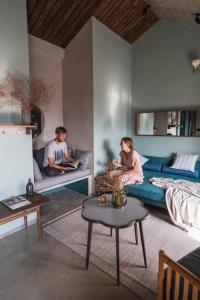 um homem e uma mulher sentados numa sala de estar em Kaia Gallery Hotel Hoi An em Hoi An
