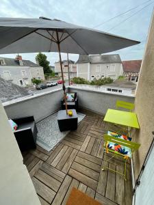 een balkon met een parasol en een tafel en stoelen bij Logement entier: Appartement avec Terrasse Quartier de la Gare in Amboise