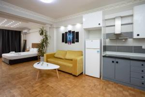 a kitchen and a living room with a couch and a table at Hestia Apartment! in Thessaloniki