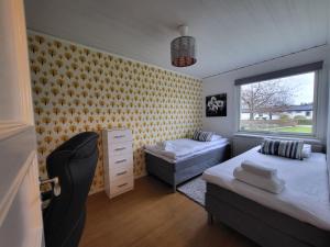 1 dormitorio con 2 camas y ventana en Villa nära Varberg och Ullared en Varberg