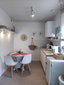 a kitchen with a table and white chairs and a table and a counter at APARTAMENT NIEBO in Kołobrzeg