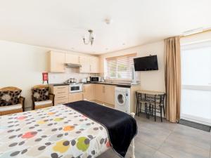 a bedroom with a bed and a kitchen at Pass the Keys Lovely Central Stratford Chalet in Stratford-upon-Avon