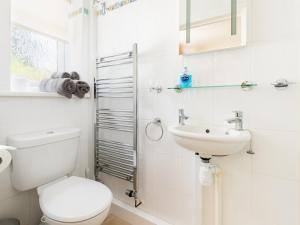 a white bathroom with a toilet and a sink at Pass the Keys Lovely Central Stratford Chalet in Stratford-upon-Avon