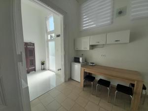 a kitchen with a table and chairs in a room at Déri Kert Apartmanház A in Baja