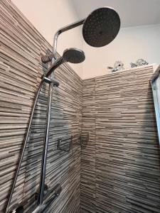 a shower in a bathroom with a wooden wall at Casa San Marco in Pisogne