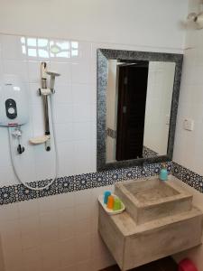 a bathroom with a sink and a mirror at RANGOON RESIDENCES + in George Town