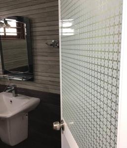 La salle de bains est pourvue d'un lavabo et d'une douche avec un miroir. dans l'établissement Private annex, 2 beds/2 rooms, à Galle