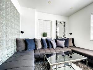 a living room with a brown couch and a glass table at 4 RM on Beach SoBeSuites by AmericanVacationLiving in Miami Beach