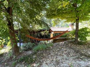 una hamaca en un jardín con cenador en “SPArisio” CASA IN SASSO CON PISCINA E CAMPO DA TENNIS, en Lama
