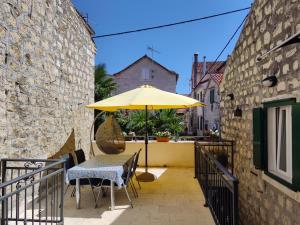 a table with a yellow umbrella on a balcony at Apartments Marin in Trogir
