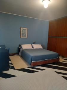 a bedroom with a bed and a blue wall at B&B Villa Tina in SantʼOmero