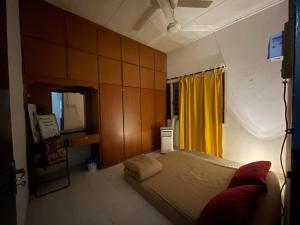 a bedroom with a bed and a yellow curtain at Roomstay Rumah Pintu Kuning in Kangar +18 photos