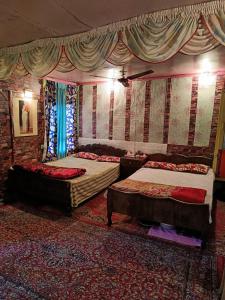 a bedroom with two beds and a wall with curtains at Hotel Island in Srinagar