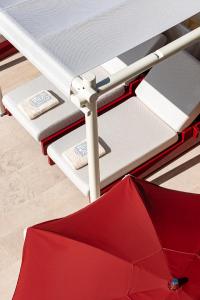 - un parapluie rouge installé au-dessus d'un lit dans l'établissement Regina Experimental Biarritz, à Biarritz