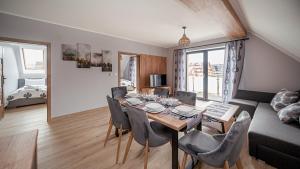 ビャウカにあるSKI APARTAMENTSのダイニングテーブルと椅子のあるリビングルーム