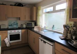 a kitchen with a counter top and a window at Ailsa Cottage in Newton Stewart