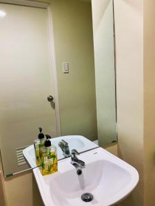 a bathroom with a white sink and a mirror at Cozynest Condotel Baguio in Baguio