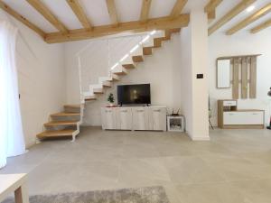 ein Wohnzimmer mit einer Treppe und einem TV in der Unterkunft Casa Venere in Ospedaletto